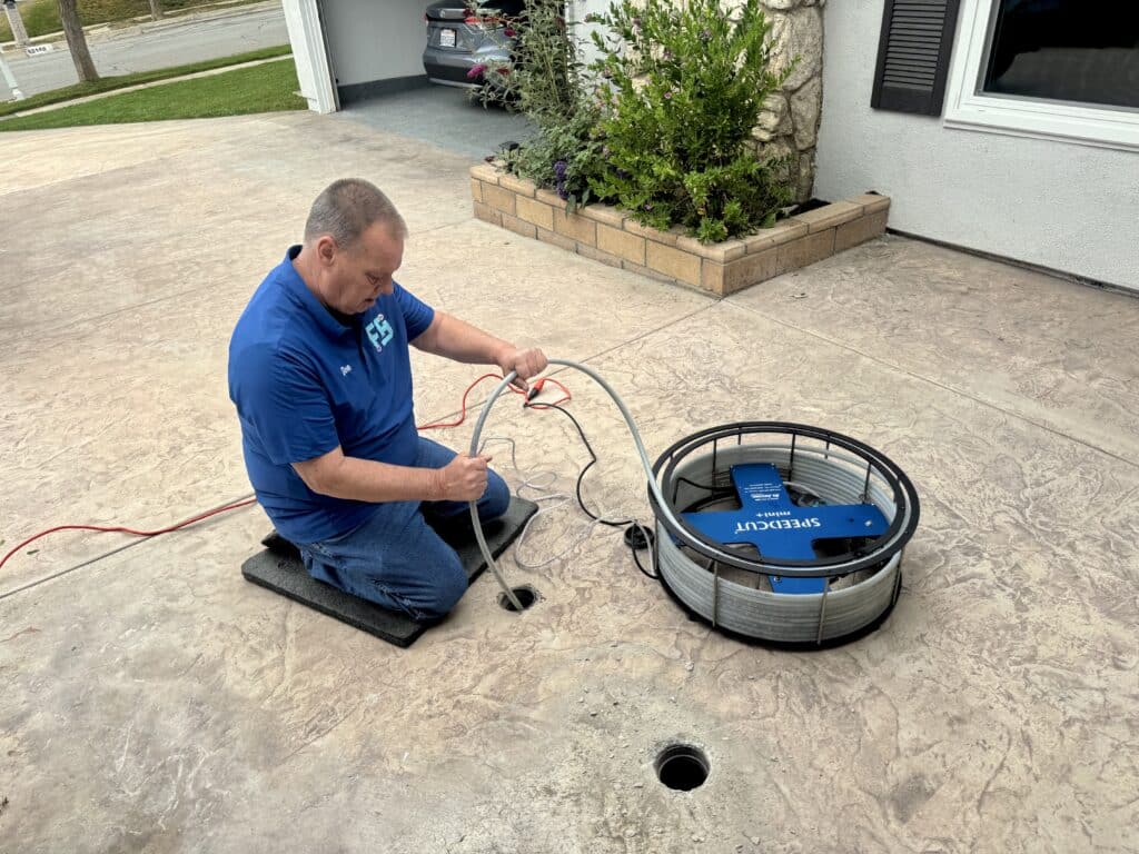 Father & Son Hydro-Jetting technician inspecting residential drain line with camera equipment